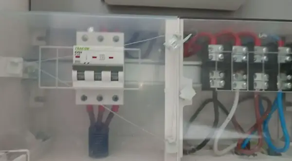 W skrzynce elektrycznej widoczny jest zabezpieczenie przedlicznikowe TRACON, połączone z innymi przewodami.