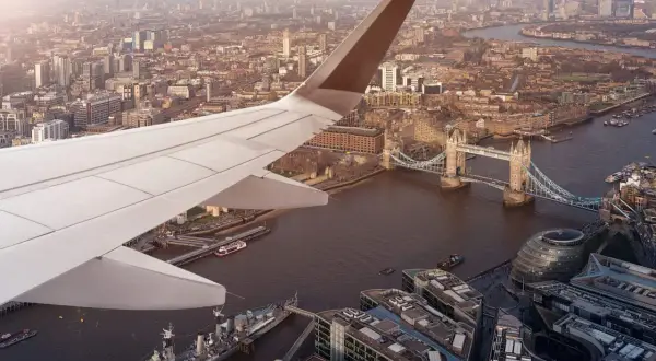 Flygplansvinge över London med Tower Bridge och floden Themsen. En vy som påminner om ankomsten till en av Londons flygplatser.