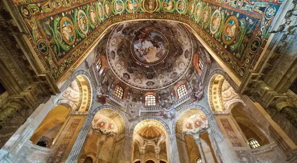 Interno di un edificio con mosaici dorati e affreschi, uno dei siti UNESCO Emilia Romagna.