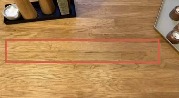 Une fissure visible sur une table en bois, nécessitant une réparation.