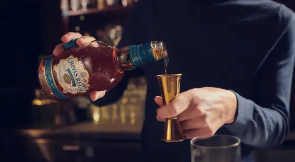Barman nalewa Chivas Regal do miarki. Czy whisky zawiera cukier? To pytanie zadaje sobie wielu miłośników tego trunku.