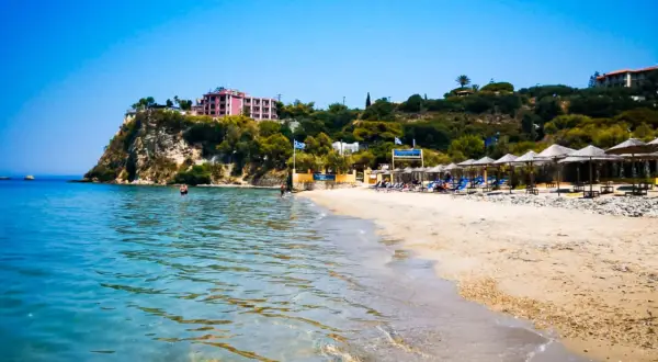 Piękna plaża Alykanas z turkusową wodą, piaszczystym brzegiem i hotelami na klifie. Idealne miejsce na wakacje.