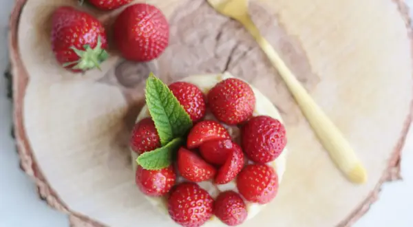 Délicieuse tarte aux fraises sans cuisson, garnie de fruits rouges frais et d'une touche de menthe. Un régal visuel et gustatif.