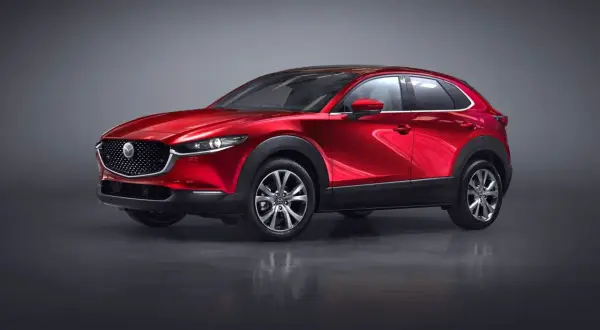 Röd Mazda CX-30 hybrid i studio. En elegant SUV redo för en provkörning.