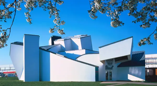 Das Vitra Museum Weil am Rhein, ein architektonisches Meisterwerk, erstrahlt im Frühlingslicht unter blühenden Kirschbäumen.