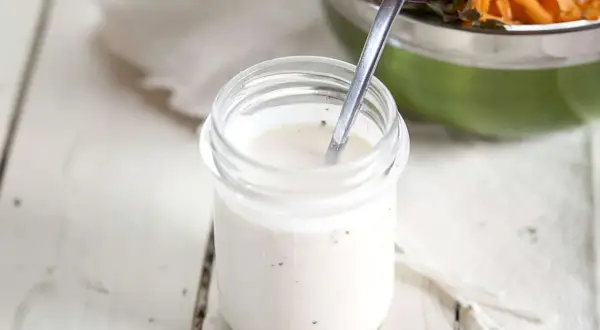 Frisches Joghurt Dressing selber machen ist einfach! Hier ein Glas mit cremiger, selbstgemachter Joghurt-Dressing-Basis, bereit für den Salat.