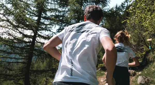 Couple en pleine course en forêt, profitant d'un moment de sport aérobie en pleine nature.