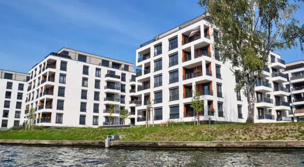 Moderne Wohnanlage am Wasser. Hier erfahren Sie, was man bei einer selbstgenutzten Eigentumswohnung steuerlich absetzen kann.