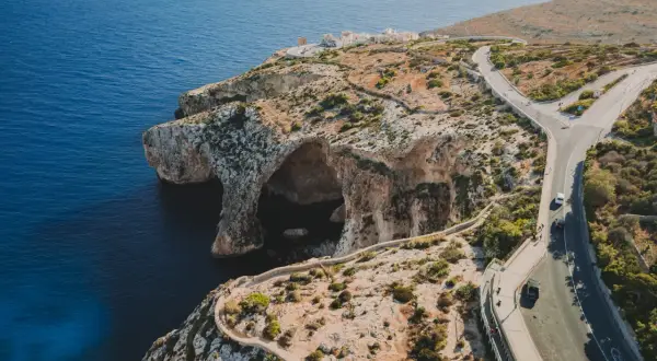Malta widoki: klify, jaskinie morskie i kręta droga nad turkusowym morzem.