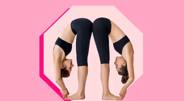 Due donne in posa yoga Uttanasana, schiena contro schiena, con le teste rivolte verso il basso.