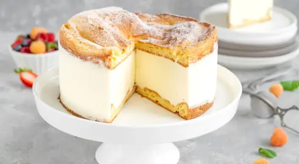Puszysty kremowy tort, jeden z 10 najlepszych ciast, z ciastem ptysiowym i owocami w tle.