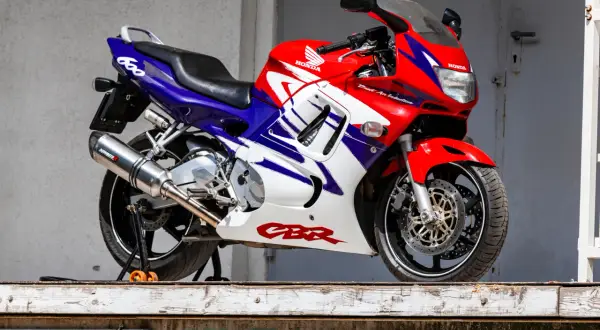 Czerwono-biało-niebieski motocykl sportowy Honda CBR 600 na stojaku.