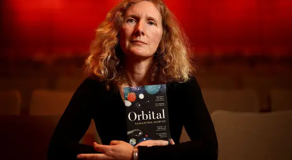 Samantha Harvey, autorka nominowana do nagrody Bookera 2023, trzyma swoją książkę "Orbital".