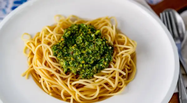 Spaghetti mit einem Berg von leckerem Pistazien Pesto, garniert mit gehackten Pistazien.