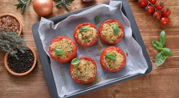Pomodori gratinati in friggitrice ad aria, ripieni e dorati, pronti per essere gustati.