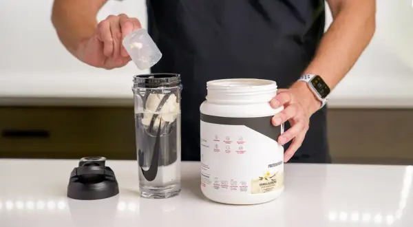 Mann bereitet einen Protein Shake vor. Ob vor oder nach dem Training, dieser Shake ist ideal.