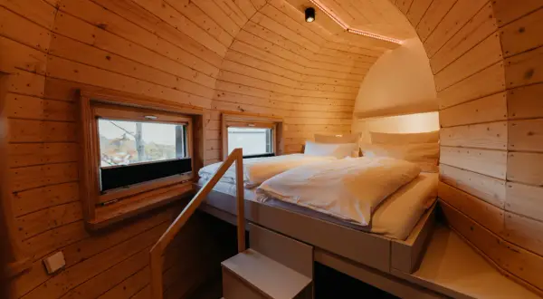 Gemütliches Holz-Schlafzimmer mit Doppelbett und Fenstern, ideal für einen erholsamen Aufenthalt in Bad Harzburg.