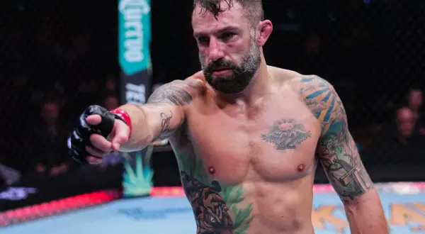 Michael Chiesa, med tatuerat bröst och armar, pekar framåt i oktagonen.