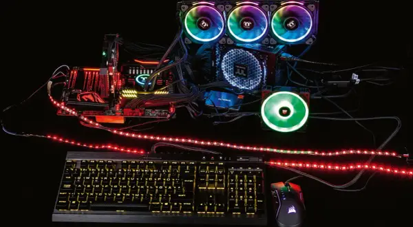 Ein PC-Aufbau mit leuchtenden Lüftern und RGB-Streifen, die zeigen, was ist RGB-Beleuchtung. Tastatur und Maus leuchten ebenfalls.