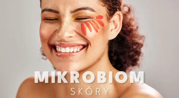 Uśmiechnięta kobieta z płatkami kwiatów na policzku. Tekst: MIKROBIOM SKÓRY.