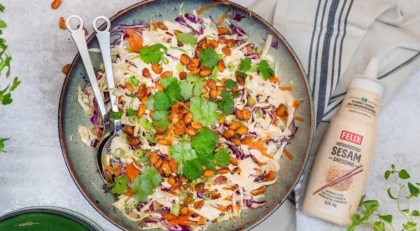 En fräsch asiatisk sallad med krispig vitkål, rödkål och morötter, toppad med rostade nötter och koriander. Serveras med Felix mörkrostade sesamdressing.