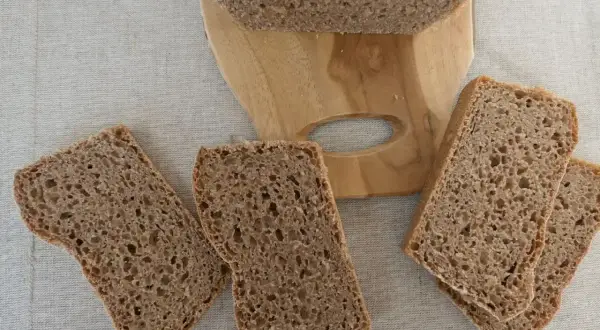 Kromki ciemnego chleba na desce, aż chce się jeść, ale potem może pojawić się zgaga po chlebie.