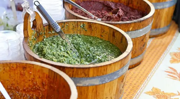 Vari tipi di pesto in botti di legno, un tripudio di sapori freschi e intensi.