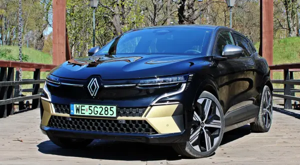 Nowy Renault Austral, czarna marka samochodu na drewnianym moście, z elementami w kolorze złota.