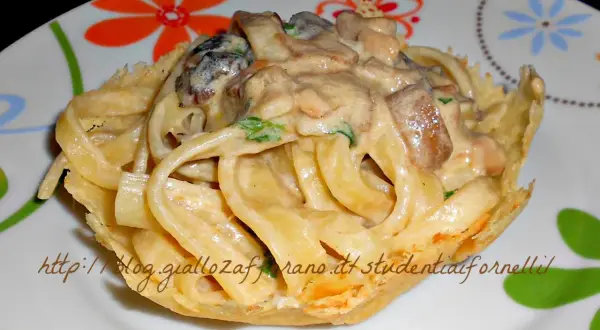 Scialatielli ai funghi cremosi serviti in un cestino croccante, un piatto invitante e saporito.