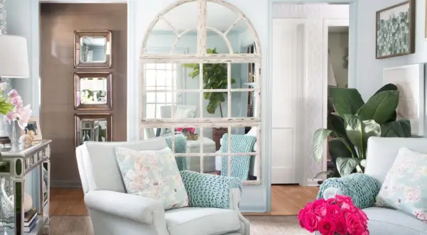 Charming mirror wall ideas: a large arched window mirror and stacked square mirrors create depth and light in this elegant living room.