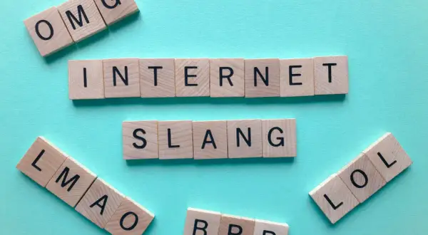 Letras de madera forman "INTERNET SLANG", "OMG", "LMAO" y "LOL". ¡El lenguaje de mañana abreviado!