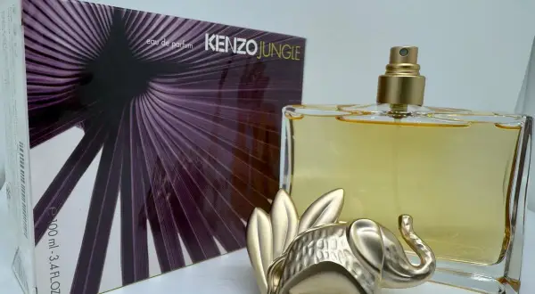 Złoty słoń strzeże flakonu Kenzo Jungle 100ml z fioletowym, liściastym wzorem na opakowaniu.
