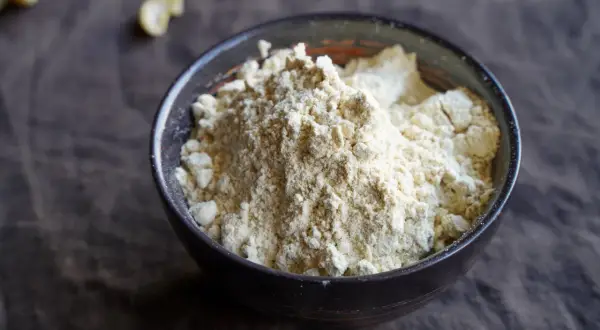 Schüssel mit hellem Proteinpulver. Man kann Proteinpulver erhitzen, um es in Backwaren zu verwenden.