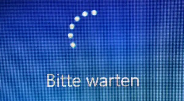 Der PC startet nicht. Ein Ladekreis und die Meldung "Bitte warten" auf blauem Hintergrund deuten auf ein Problem hin.