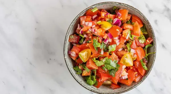 En skål med färsk pico de gallo, full av tärnad tomat, rödlök och koriander. Perfekt till tacosen!