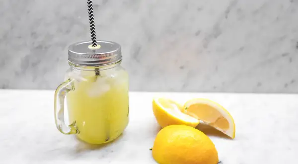 En burk med hemgjord lemonad, is och citronskivor. Perfekt för ett enkelt lemonad recept.