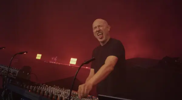 Paul Kalkbrenner na koncertach w Polsce, w transie za konsolą, z językiem na wierzchu.