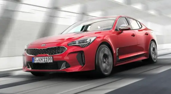 Czerwony Kia Stinger pędzi przez tunel. Sprawdź atrakcyjną kia stinger cena!