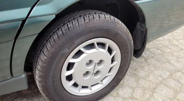 Srebrna felga z logo Daewoo na zielonym samochodzie.