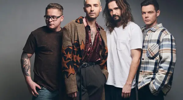 Tokio Hotel Polska: czterech mężczyzn w stylowych strojach pozuje do zdjęcia. Jeden z nich ma tatuaż na ramieniu.