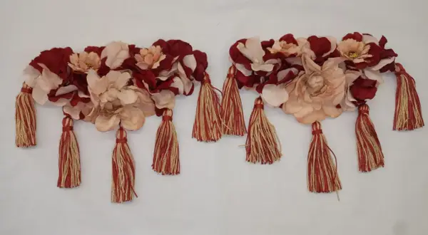 Dos adornos florales con borlas rojas y doradas, perfectos para saber como hacer hombreras flamencas.