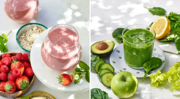 Två glas med färgglada smoothies, omgivna av ingredienser som hallon, havre, spenat och äpple. Perfekt för ett hälsosamt smoothie recept.