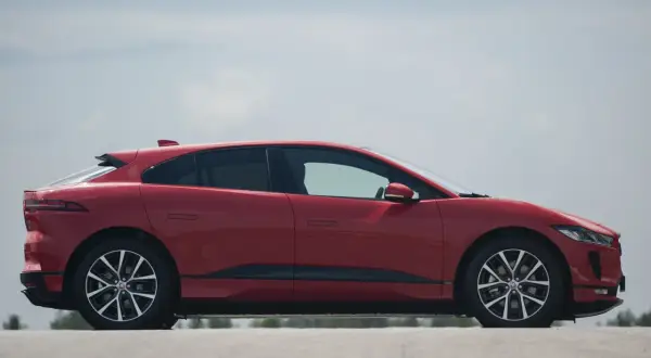 Czerwony Jaguar I-PACE na tle błękitnego nieba. Elegancki, elektryczny SUV gotowy do dynamicznej jazdy.