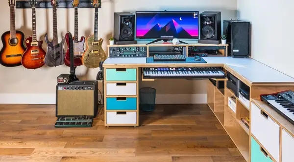 A musician's dream setup for computer music creation, featuring guitars, keyboards, speakers, and a powerful computer.