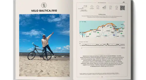 Rowerzystka na plaży z rowerem, obok mapa trasy Velo Baltica/R10. To nie są trasy rowerowe Słowacja, lecz polskie wybrzeże Bałtyku.