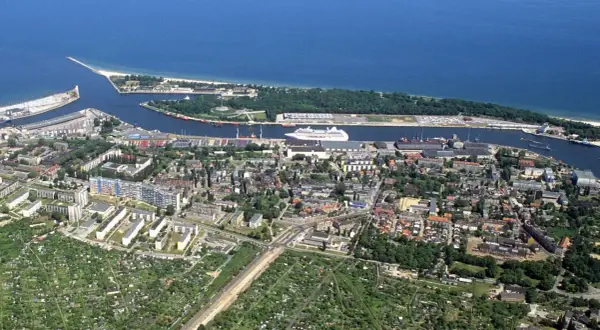 Widok na nowy port gdańsk z morzem, statkami i miastem.