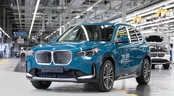 Niebieski BMW iX1, 100 000. wyprodukowany w Niemczech, w fabryce w Ratyzbonie.