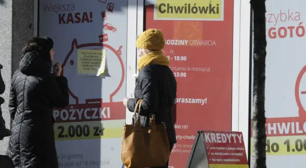 Kobiety przed placówką chwilówek. Reklamy kuszą "szybką gotówką", choć w tle czają się największe skandale z ustawianiem losowań w firmach oferujących chwilówki.