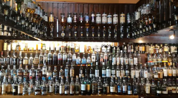 Wielka półka pełna butelek szkockiego piwa i whisky, gotowych do degustacji.