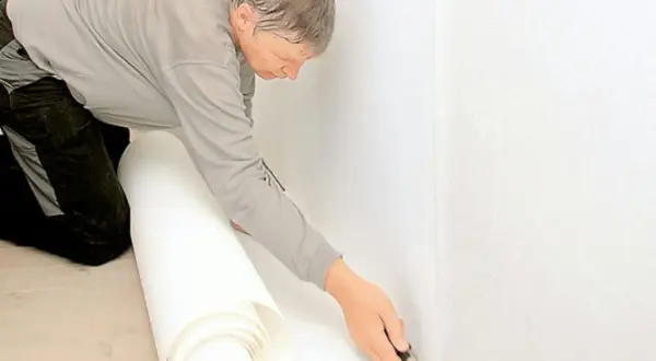 Man skär tapet för renovering. Noggrant arbete med renoveringstapet skarvar för ett perfekt resultat.